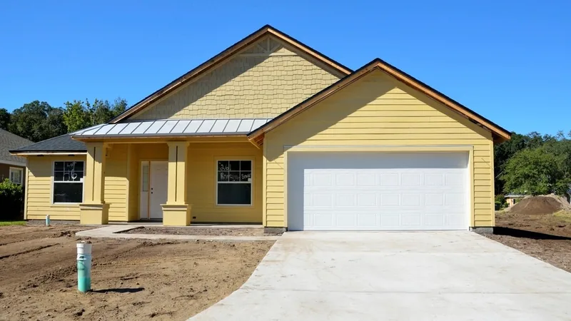 A newly built yellow family house with a garage