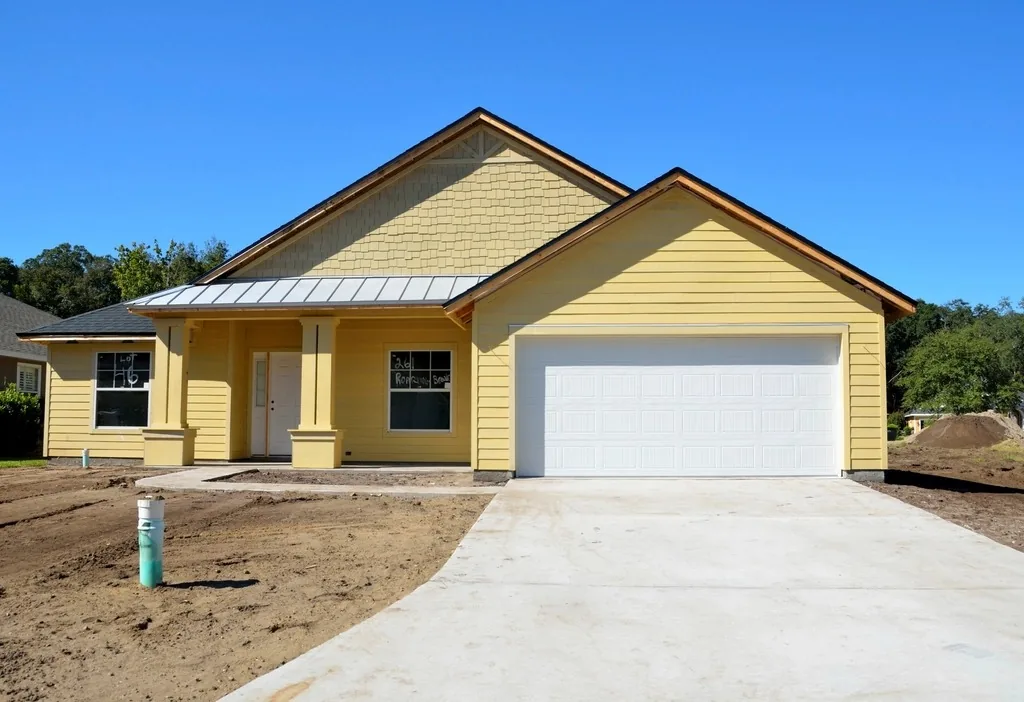 A newly built yellow family house with a garage