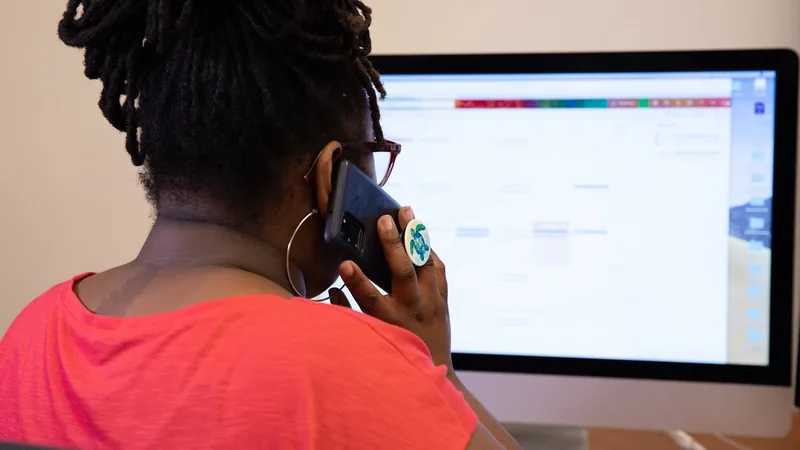 A woman on the phone at her computer