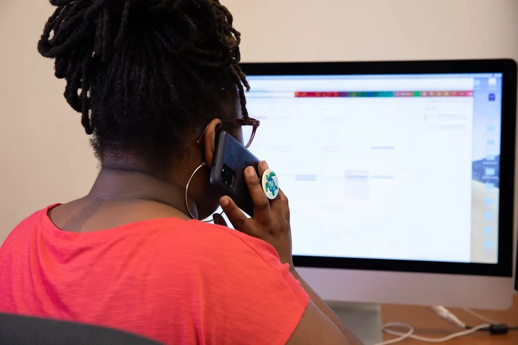 A woman on the phone at her computer